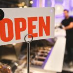 A vibrant open sign in a Los Angeles shop with a blurred figure in the background.